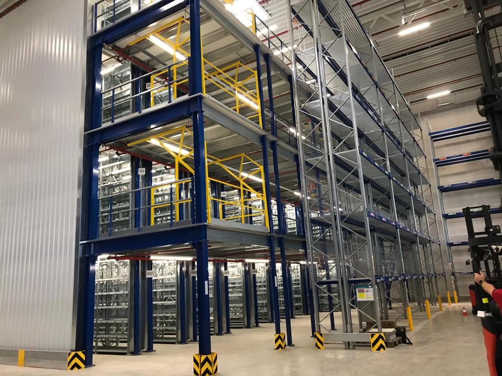 Mezzanine vloer op maat in magazijn met stalen constructie, leuningen en tussenplatformen