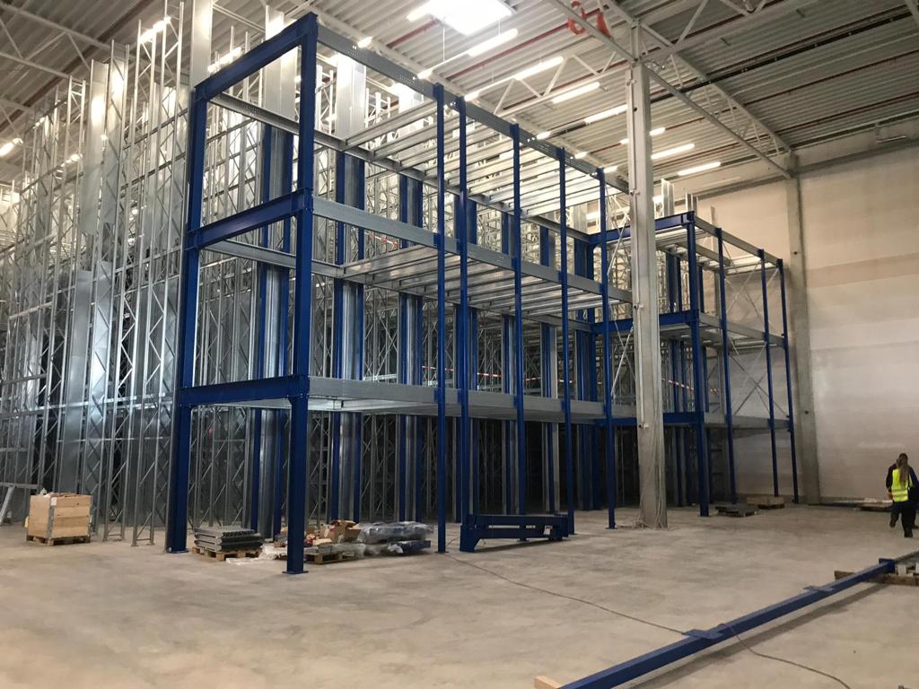 Mezzanine vloer op maat, stalen constructie met kolommen en draagbalken in magazijn