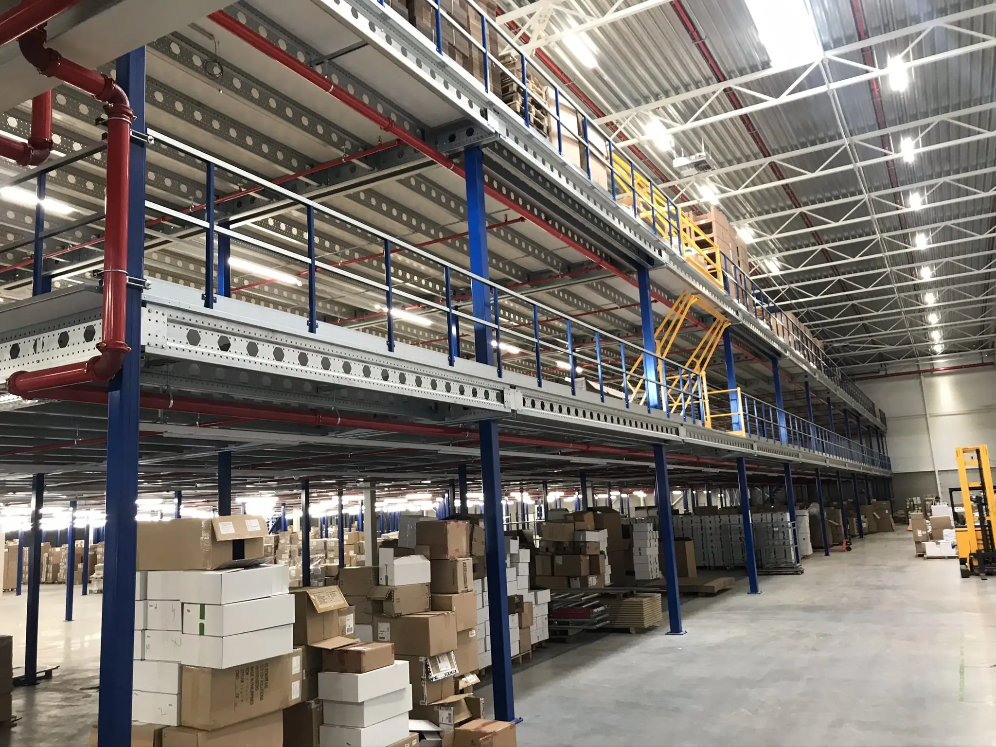 Mezzanine vloer met meerdere niveaus, opslagdozen en stevige balustrades.