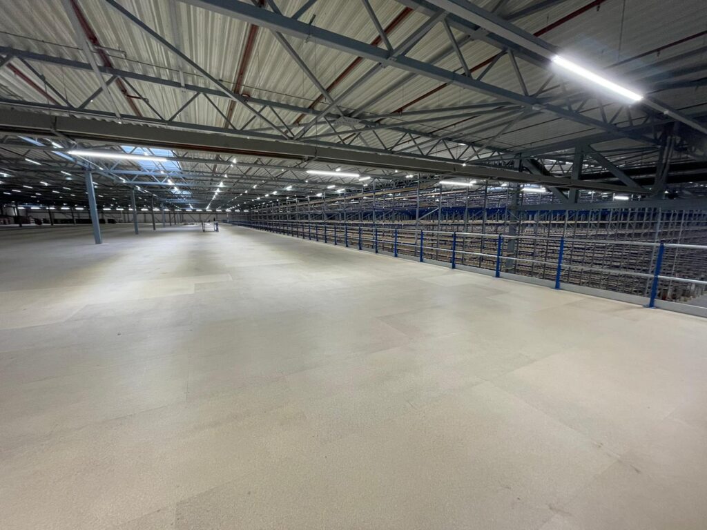 Mezzanine vloer op maat met stalen constructie, vloerplaten en leuning in magazijn
