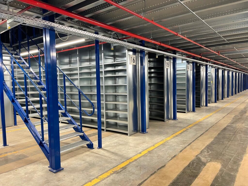 Mezzanine vloer op maat met stalen constructie, trap en legplanken in magazijn