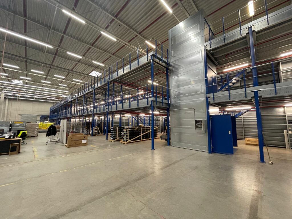 Mezzanine vloer op maat met stalen constructie, trap en leuning in ruime magazijn