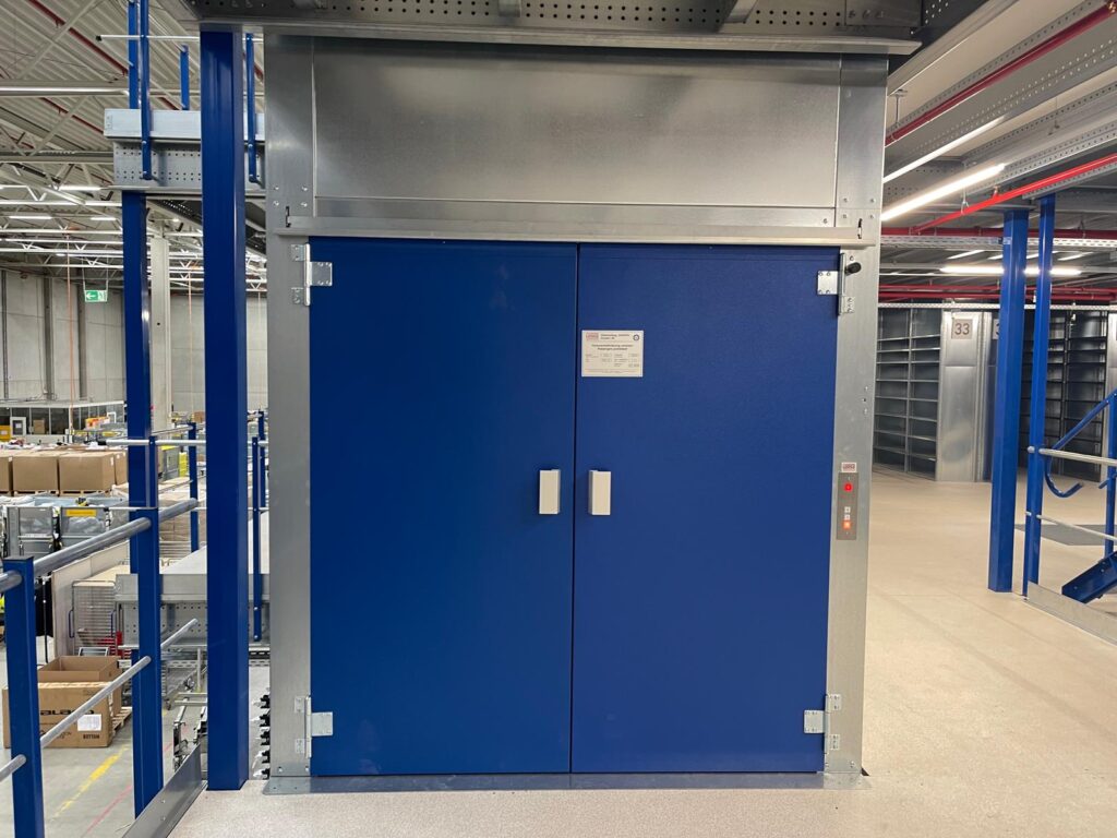 Mezzanine vloer met op maat gemaakte goederenlift en stalen constructie, leuning en vloerplaten in magazijn