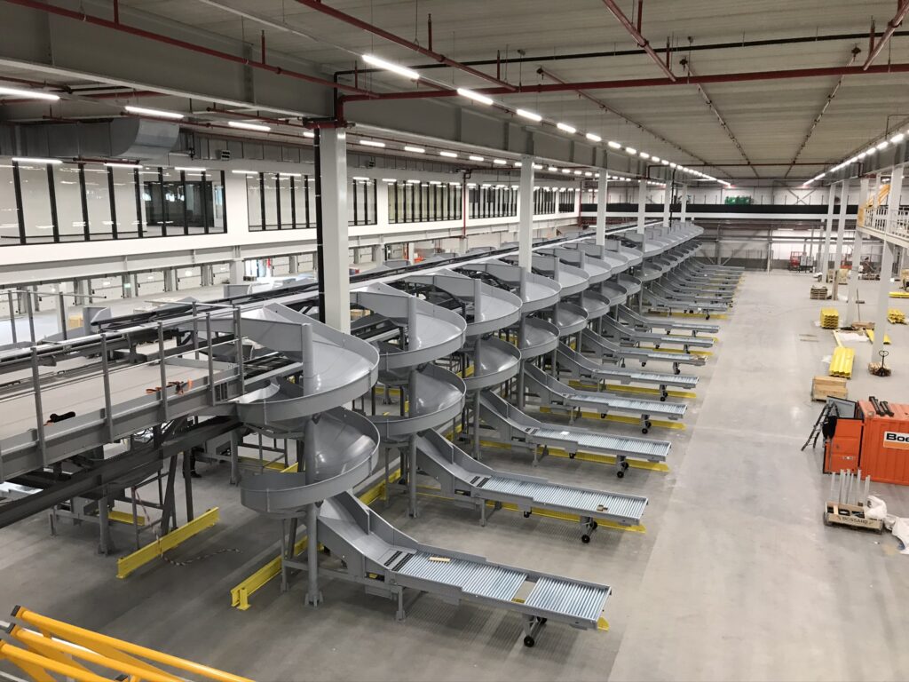 Mezzanine vloer op maat met stalen constructie en spiraaltrappen in grote magazijn