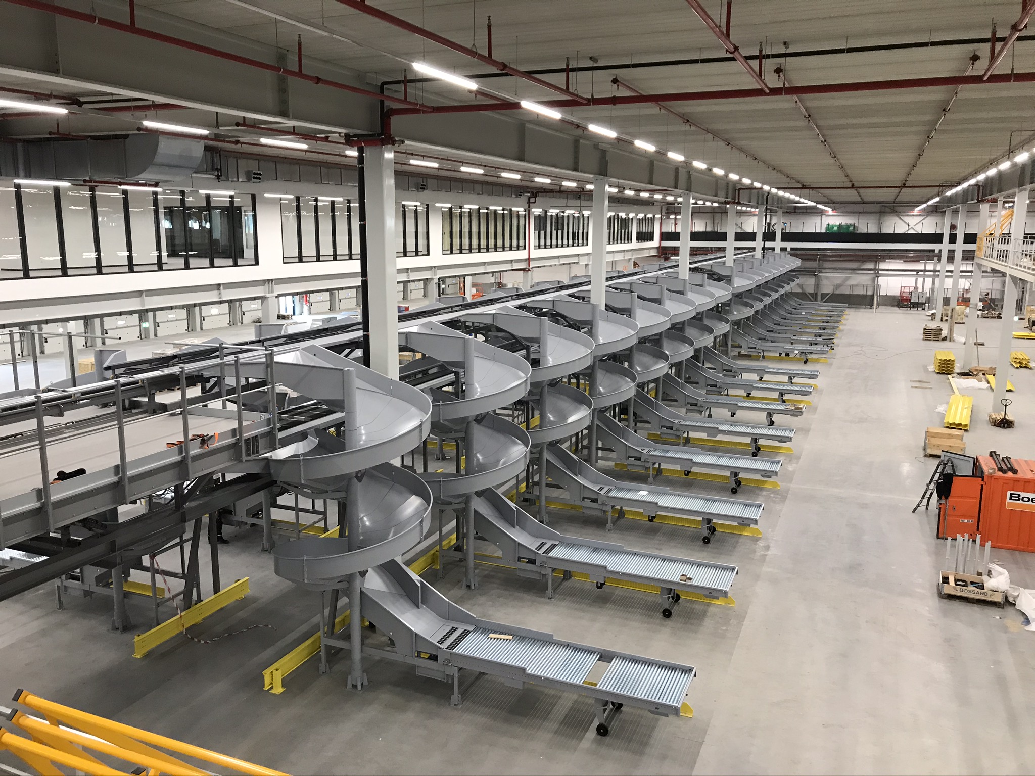 Mezzanine vloer op maat met stalen constructie en spiraaltrappen in grote magazijn