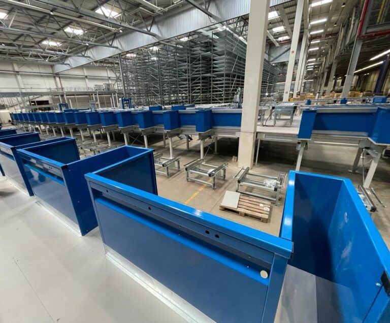 Mezzanine vloer op maat met stalen constructie en leuning boven transportbanden in magazijn