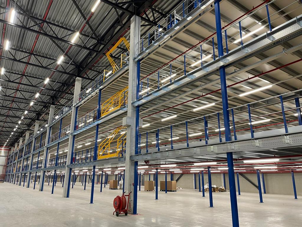 Entresolvloer met stalen constructie gele trap en leuningen op maat voor loods