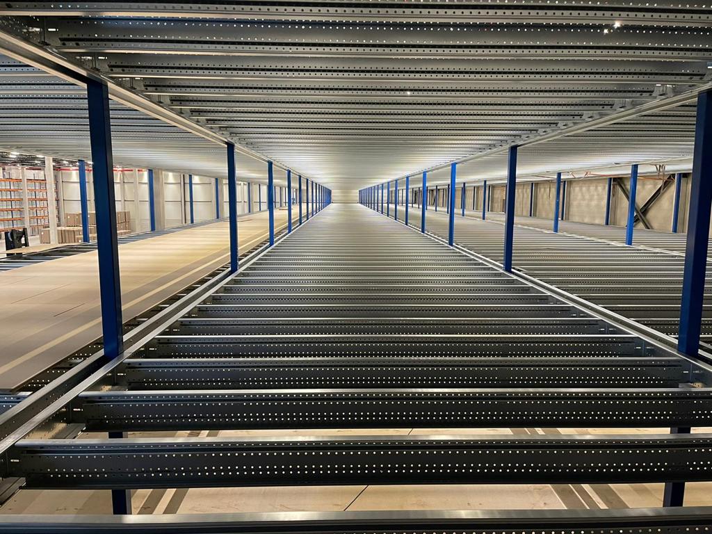 Entresolvloer op maat met stalen constructie, vloerplaten en blauwe kolommen in loods