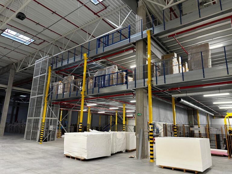 Verdiepingsvloer op maat met stalen constructie, gele kolommen, trappen en reling in bedrijfshal