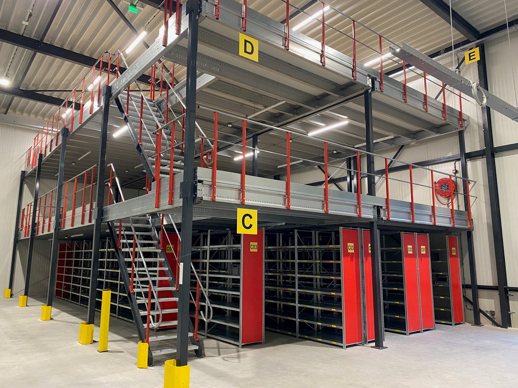 Mezzanine vloer op maat met stalen constructie, trap en leuning in magazijn