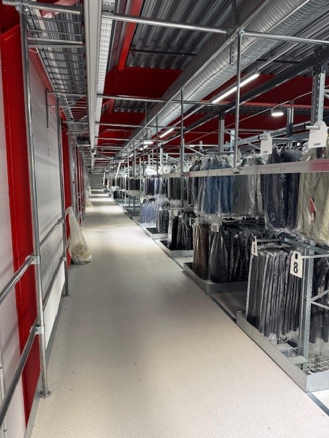 Mezzanine vloer met stalen constructie, loopgang en kledingrekken op maat magazijn